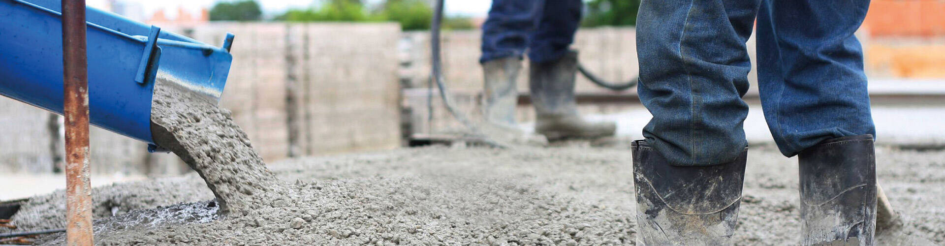   Um caminh&atilde;o despejando concreto no campo de obra.